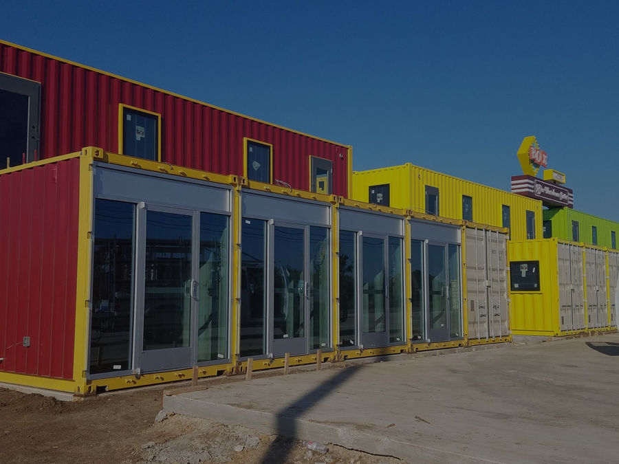 Container building with full storefront glass panels