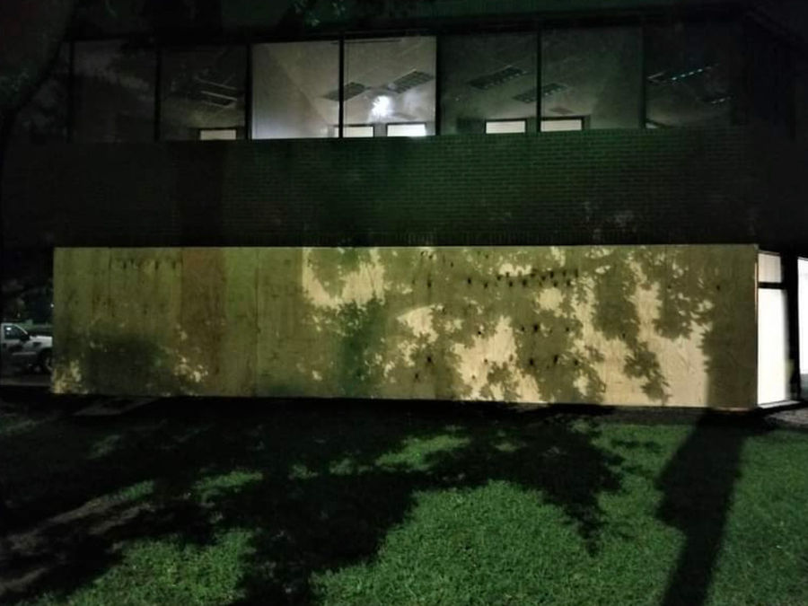 Emergency board-up with plywood covering commercial building at night